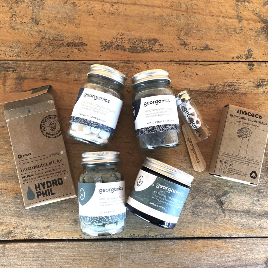 Assorted eco-friendly dental products on a wooden surface.