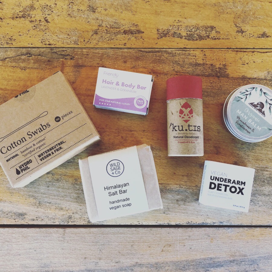 Assorted eco-friendly personal care products on a wooden surface.