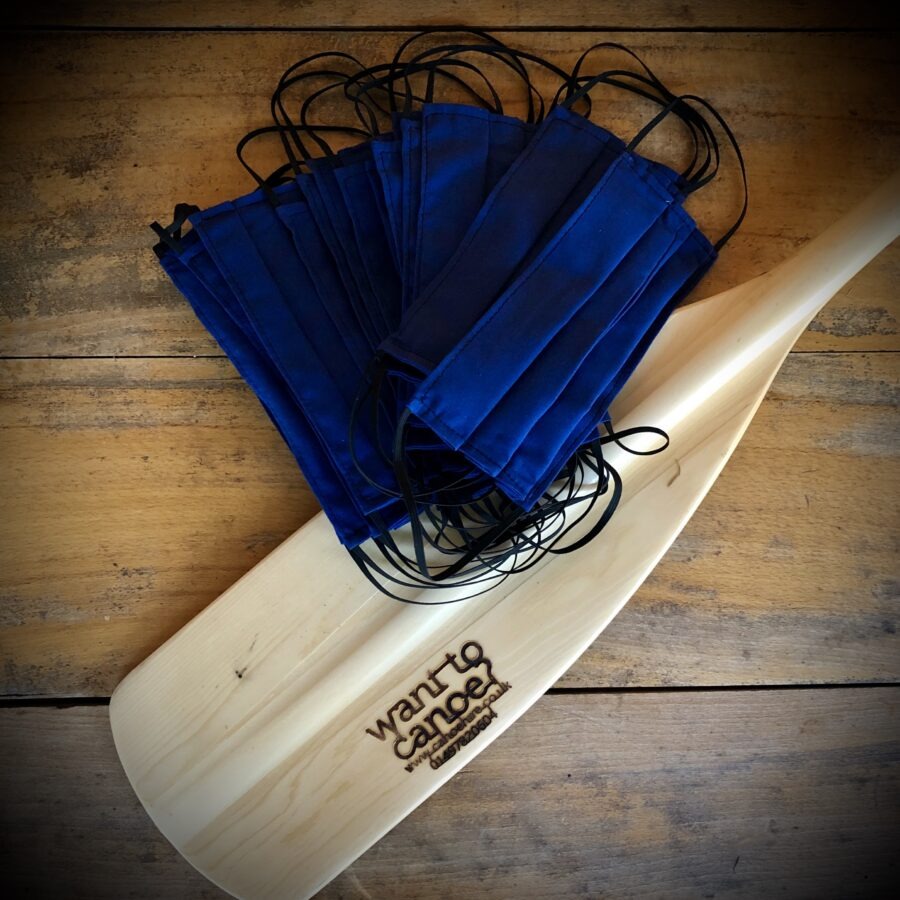 Blue masks on a paddle with 'want to cancer' inscription on wooden surface.